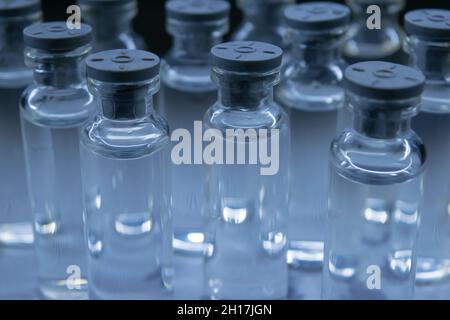 Mehrere Flaschen mit klarer Flüssigkeit auf dem Tisch. Stockfoto