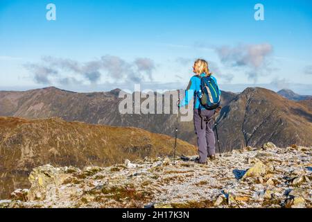 Ein Bergwanderer surverys den mächtigen Aonach Eagach Ridge in Glencoe, Schottland, von Buachaille Etive Beag aus gesehen Stockfoto