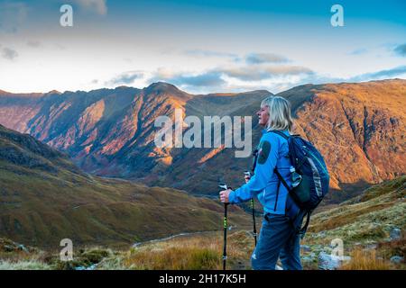 Ein Bergwanderer surverys den mächtigen Aonach Eagach Ridge in Glencoe, Schottland, von Buachaille Etive Beag aus gesehen Stockfoto