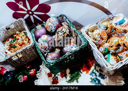 Korbkörbe mit Weihnachtsspielzeug-Kugeln im Winter-Design. Weihnachtsbaum und festliche Neujahrsstimmung. Urlaubskonzept Stockfoto