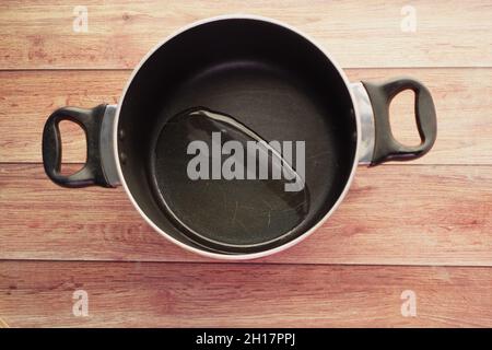 Draufsicht auf das Gießen von Pflanzenöl in die Bratpfanne. Stockfoto