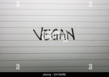 Eine Nahaufnahme einer handschriftlichen Notiz mit der Aufschrift „Veganre“ auf einem weißen Notizbuch Stockfoto