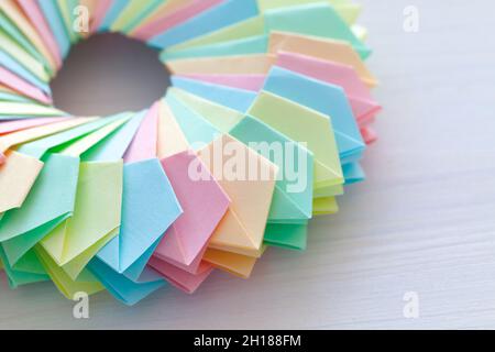 Origami, Fragment eines abstrakten parametrischen Rings aus bunten Papierblättern, lag auf einem weißen Schreibtisch, Draufsicht Stockfoto