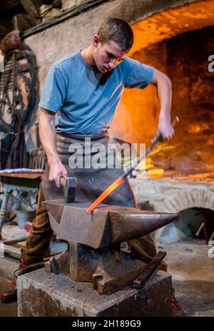 17. Oktober 2021, Sachsen, Olbernhau: Der handwerkliche Schmied Thore Krauter zeigt seinen Besuchern sein Handwerk bei einer Schauschmiede im Kupferhammer in der Saigerhütte. Am 22. Tag des traditionellen Handwerks im Erzgebirge öffnen zahlreiche Handwerksbetriebe aus verschiedenen Branchen ihre Türen. Foto: Kristin Schmidt/dpa-Zentralbild/ZB Stockfoto