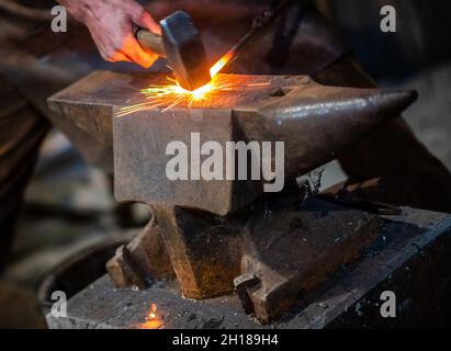 17. Oktober 2021, Sachsen, Olbernhau: Der handwerkliche Schmied Thore Krauter zeigt seinen Besuchern sein Handwerk bei einer Schauschmiede im Kupferhammer in der Saigerhütte. Am 22. Tag des traditionellen Handwerks im Erzgebirge öffnen zahlreiche Handwerksbetriebe aus verschiedenen Branchen ihre Türen. Foto: Kristin Schmidt/dpa-Zentralbild/ZB Stockfoto