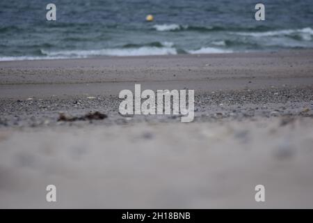 Verschiedene Schwerpunkte eines Strandes gegen das Meer mit einer kleinen schwimmenden Boje Stockfoto