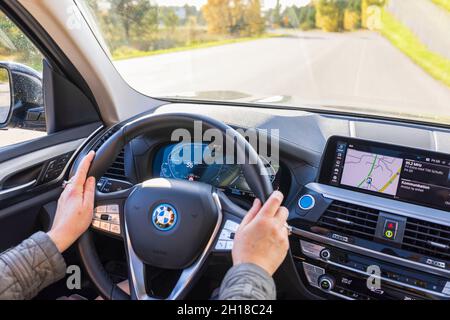 Nahaufnahme der weiblichen Hände am Lenkrad des Elektroautos BMW iX3. Schweden. Uppsals. Stockfoto