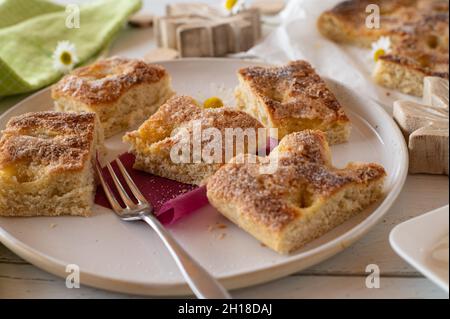 Butterkuchen mit Zuckerkuchen. Köstliche Torte oder Hefekuchen mit Butter und mit Zucker gekrönt. In Stücken auf einem Teller mit Gabel serviert Stockfoto