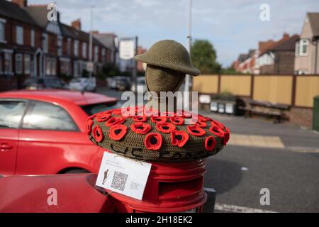 New Brighton UK Oktober 2021 Red Poppy Fund Raiser Royal british Legion Appeal auf roten Briefkästen mit gestricktem tommy und Helm Stockfoto