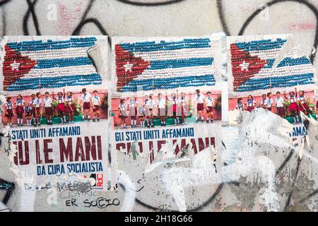 Gli Stati Uniti Affamano Giu le Mani da Cuba Socialista. Zerrissene politische Weizenplakate an der Wand in Rom, Italien. Stockfoto