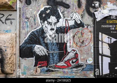 Das in Form geschnittene Street-Art-Poster von Charlie Chaplin, der Nike Sneaker isst. Trastevere Viertel von Rom, Italien. Stockfoto