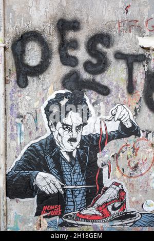 Charlie Chaplin isst Nike Sneaker. In Form zugeschnittenes Poster für Street Art im Stadtteil Trastevere in Rom, Italien. Stockfoto