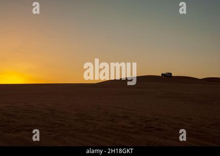 SUV auf Sanddünen bei Sonnenuntergang im Erg Awbari. Fezzan, Libyen Stockfoto