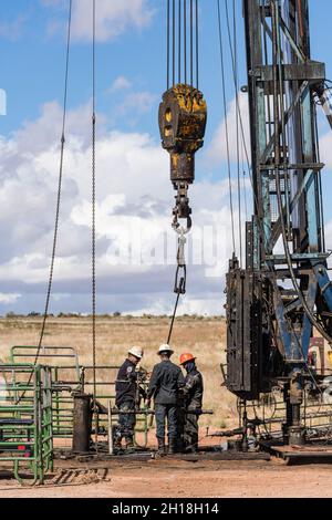 Die Brunnendienstmannschaft auf einer Überarbeitungs-Rig arbeitet an einer Ölbohranlage, um zu versuchen, sie wieder in Betrieb zu nehmen. Stockfoto