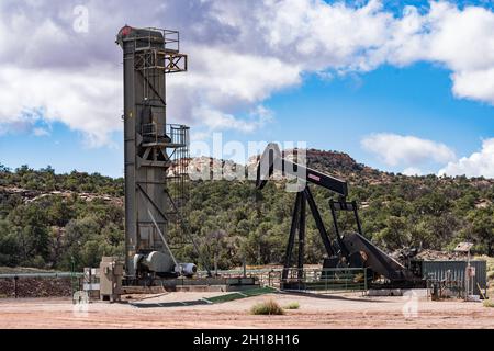 Eine langhubige Riemenpumpe und ein traditioneller Pumpenheber an benachbarten Ölquellen im Canyon-Land von Utah. Stockfoto