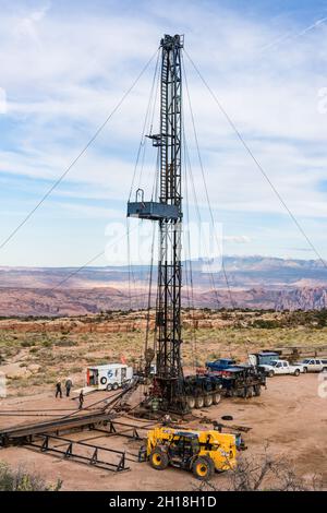 Eine Zieheinheit oder ein Überarbeitungs-Rig an einer Ölbohrstelle in Utah. Dahinter liegen die La Sal Mountains & Behind The Rocks. Stockfoto