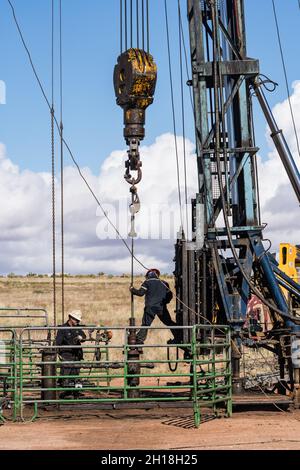 Die Brunnendienstmannschaft auf einer Überarbeitungs-Rig arbeitet an einer Ölbohranlage, um zu versuchen, sie wieder in Betrieb zu nehmen. Stockfoto