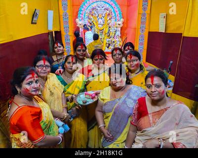 KALKUTTA, WESTBENGALEN, INDIEN - 15. OKTOBER 2021: Verheiratete bengalische Hindu-Frauen schmieren und spielen während der traditionellen Zeremonie von Sindur Khela mit Zinnober Stockfoto