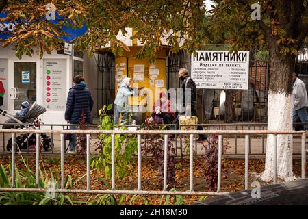 Tiraspol, Moldawien - 15. Oktober 2021 Eine Frau verkauft Blumen und Schutzmasken gegen die Coronavirus-Pandemie auf einer Straße in der Stadt Tiraspol i Stockfoto