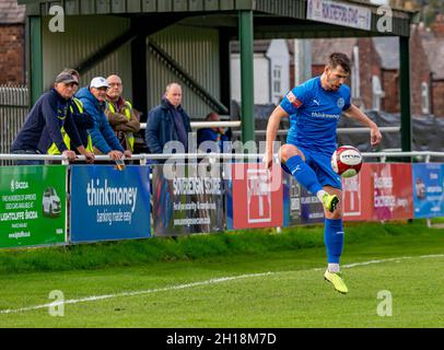 Der FC Warrington Rylands 1906 veranstaltete Kidsgrove Athletic für ein Fußballspiel der Saison 2021-2022, bei dem Rylands-Spieler den Ball kontrolliert Stockfoto