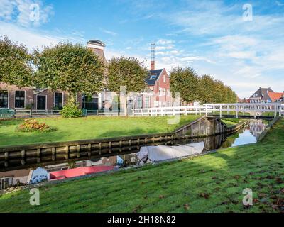 Häuser mit Gärten am Wasser am Kanal Eegracht in der Stadt IJlst, Friesland, Niederlande Stockfoto