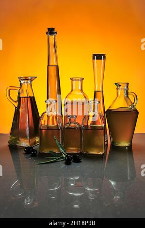 Flaschen von nativem Olivenöl, mit farbigem Hintergrund. Stockfoto