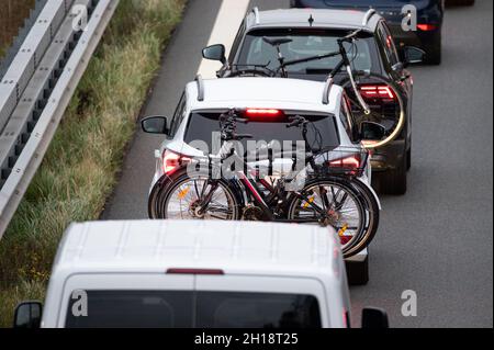 Hamburg, Deutschland. Oktober 2021. Zwei Autos mit Fahrrädern stecken in einem Stau auf der Autobahn 1 fest. Die Herbstferien in Hamburg und Schleswig-Holstein gingen am Wochenende mit Staus von Autos auf den Straßen zu Ende. Quelle: Jonas Walzberg/dpa/Alamy Live News Stockfoto