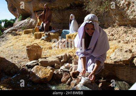 Motril, Granada, Spanien, 23. Dezember 2018: Nachbildung einer Weihnachtskrippe im Anbau von Motril de Tablones. Mädchen Wäsche waschen in einem stre Stockfoto