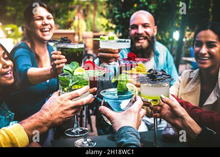 Modische Menschen halten bunte Getränke - trendige Freunde, die Spaß haben zusammen Cocktails trinken zur Happy Hour - Gesellschaftsparty Zeit Stockfoto
