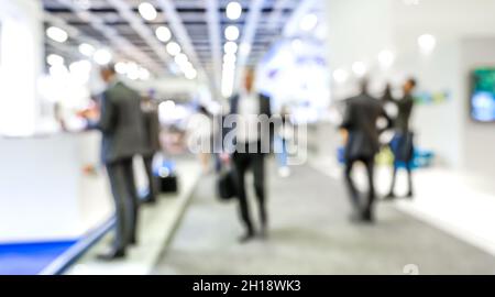 Defokussierte Bokeh-Zusammenfassung der Geschäftsleute auf Generic Trade Show expo Stand - Business und Social Gathering Konzept auf der internationalen Tourismus-Messe Stockfoto