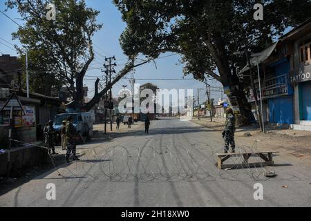 Srinagar, Indisch Verwaltetes Kaschmir. 16. Oktober 2021: Indische paramilitärische Truppen stehen am 16. Oktober 2021 auf einer verlassenen Straße während einer Waffenschlacht zwischen indischen Streitkräften und Militanten im Pampore-Gebiet des Pulwama-Distrikts südlich von Srinagar, dem von Indien verwalteten Kaschmir, in Alarmbereitschaft. Zwei Militante wurden bei der Schießerei getötet, vier Wohnhäuser wurden jedoch beschädigt, von denen eines von indischen Truppen geblasen wurde. Stockfoto
