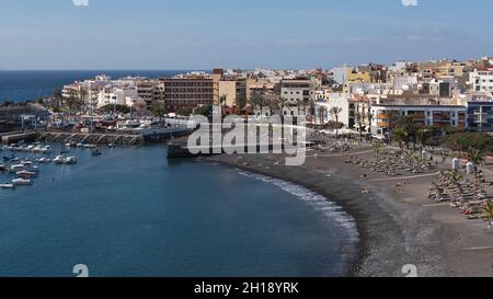 Blick auf den Hafen, die Stadt und den kleinen Strand mit schwarzem Sand, Lapilli und Kieselsteinen, der von vielen Touristen am Playa San Juan besucht wird Stockfoto