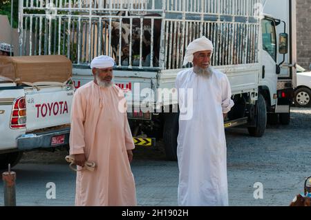 Zwei Männer in traditioneller Kleidung auf dem Nizwa-Viehmarkt. Nizwa, Oman. Stockfoto