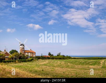 Eine alte Klippenwindmühle wurde in Weybourne an der Nordküste von Norfolk, East Anglia, England, zu einem Wohnhaus und angrenzenden Feldern umgebaut Stockfoto