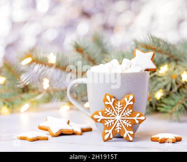 Niedliche Weihnachten Schneeflocke Lebkuchen Cookie vor einer Tasse heiße Schokolade mit Marshallows. Stockfoto