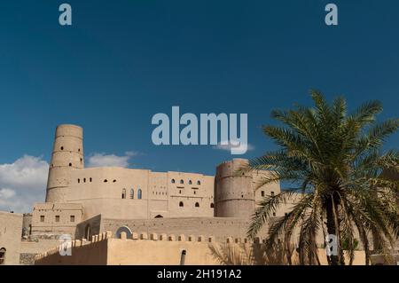 Das Bahla Fort, erbaut im 13. Jahrhundert, und eine Palme. Bahla, Oman. Stockfoto