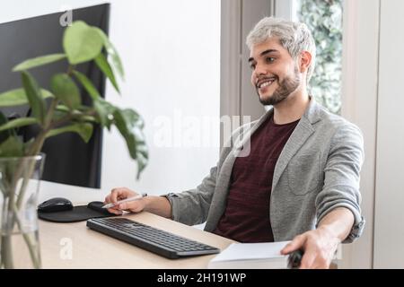 Junger Hipster-Mann arbeitet im modernen Büro - Business Lifestyle und Technologie Konzept - Fokus auf Gesicht Stockfoto