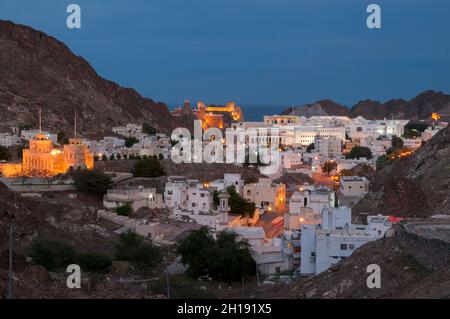 Die alte Stadt Muscat, eingebettet in ein Bergtal am Persischen Golf, in der Dämmerung. Alter Maskat, Maskat, Oman. Stockfoto