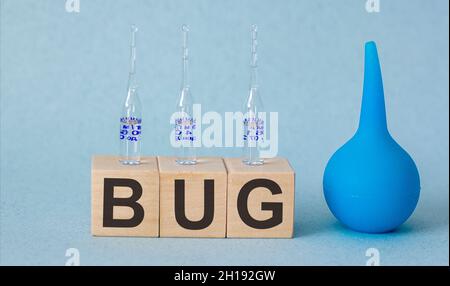 Auf Holzwürfeln der Text Bug, Ampullen und Einlauf auf blauem Hintergrund Stockfoto