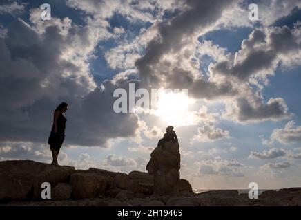 Eine Frau betrachtet „Sol Alter“, eine Bronzeskulptur von Yiota Ioannidou, die sich neben dem Fort von Paphos, Paphos, Zypern, befindet. Stockfoto