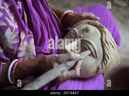 Eine weibliche Idol-Macherin, die vor dem bevorstehenden Durga Puja Festival in Agartala, Tripura, Indien, den Tonkopf der Hindu-Göttin Durga in einem Studio macht. Stockfoto