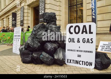 London, Großbritannien. Oktober 2021. Taschen, die wie große Kohlenklumpen und Plakate gegen fossile Brennstoffe aussehen, sind während des Protestes vor dem Wissenschaftsmuseum zu sehen. Extinction Rebellion-Aktivisten versammelten sich vor dem Museum in South Kensington vor dem Global Investment Summit, der am 19. Oktober stattfand, um gegen das zu protestieren, was sie als eine "Greenwash-Plattform" für einige der weltweit führenden Verursacher und Unternehmen bezeichnen, die fossile Brennstoffe finanzieren. Kredit: SOPA Images Limited/Alamy Live Nachrichten Stockfoto