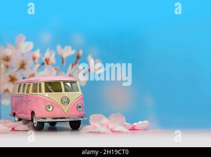 tokio, japan - juli 30 2021: Süßes rosafarbenes kleines Auto aus Druckguss, das den kultigen Volkswagen Kombi-Kleinbus aus den sechziger Jahren zeigt und wieder Blütenblätter zeigt Stockfoto