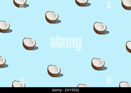 Kreatives Muster mit Kokosnuss auf blauem Hintergrund. Minimales Sommerkonzept. Stockfoto