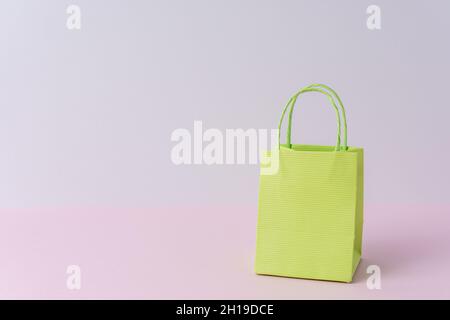 Bunte Papier-Einkaufstasche auf hellem Hintergrund. Kreatives Minimal-Shopping-Konzept. Stockfoto