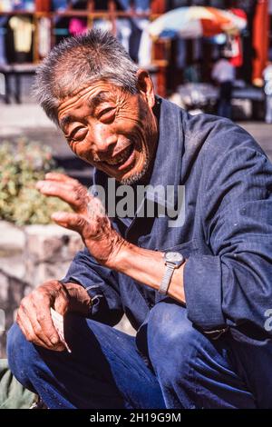 Ein alter Bauer, der Produkte auf einem Bauernmarkt im Freien in Mutianyu, China, verkauft. Stockfoto