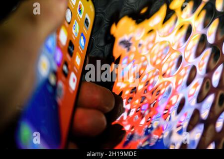 Nahaufnahme des neuesten iPhone 13 Pro-Bildschirms von Apple Computers, der sich in einer futuristischen Metallic-Oberfläche widerspiegelt Stockfoto