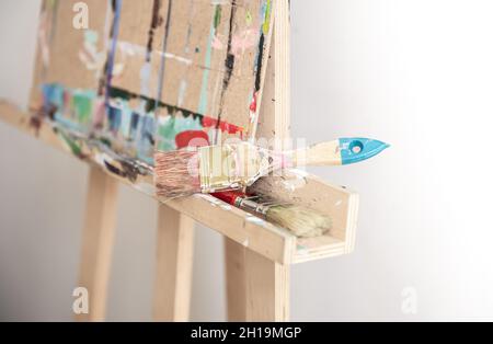 Pinsel zum Malen auf einer Staffelei stehen auf verschwommenem Hintergrund. Stockfoto
