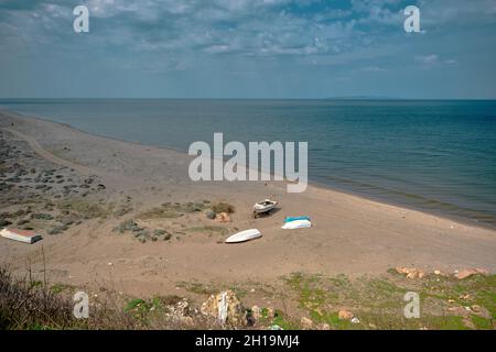 Küste in Mudanya, Bursa. Sand und türkisfarbenes marmarameer und kleine Fischerboote, die am Sandstrand liegen Stockfoto