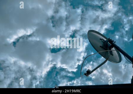 Satellitenschüssel und riesige weiße und blaue Wolken Hintergrund. Stockfoto